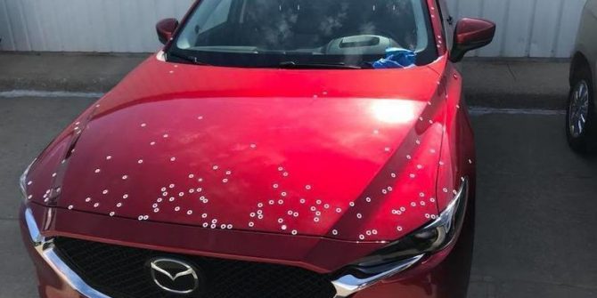 red mazda car with paint chips