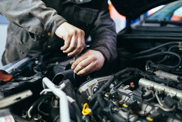 auto mechanic working on car engine