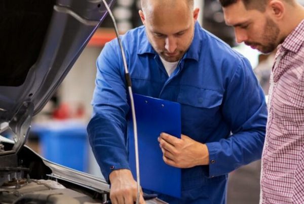 mechanic with customer looking in engine bay